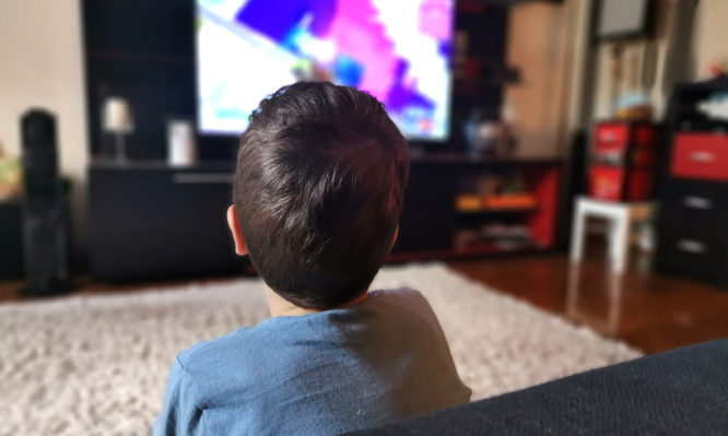 παιδί βλέπει καθιστό τηλεόραση