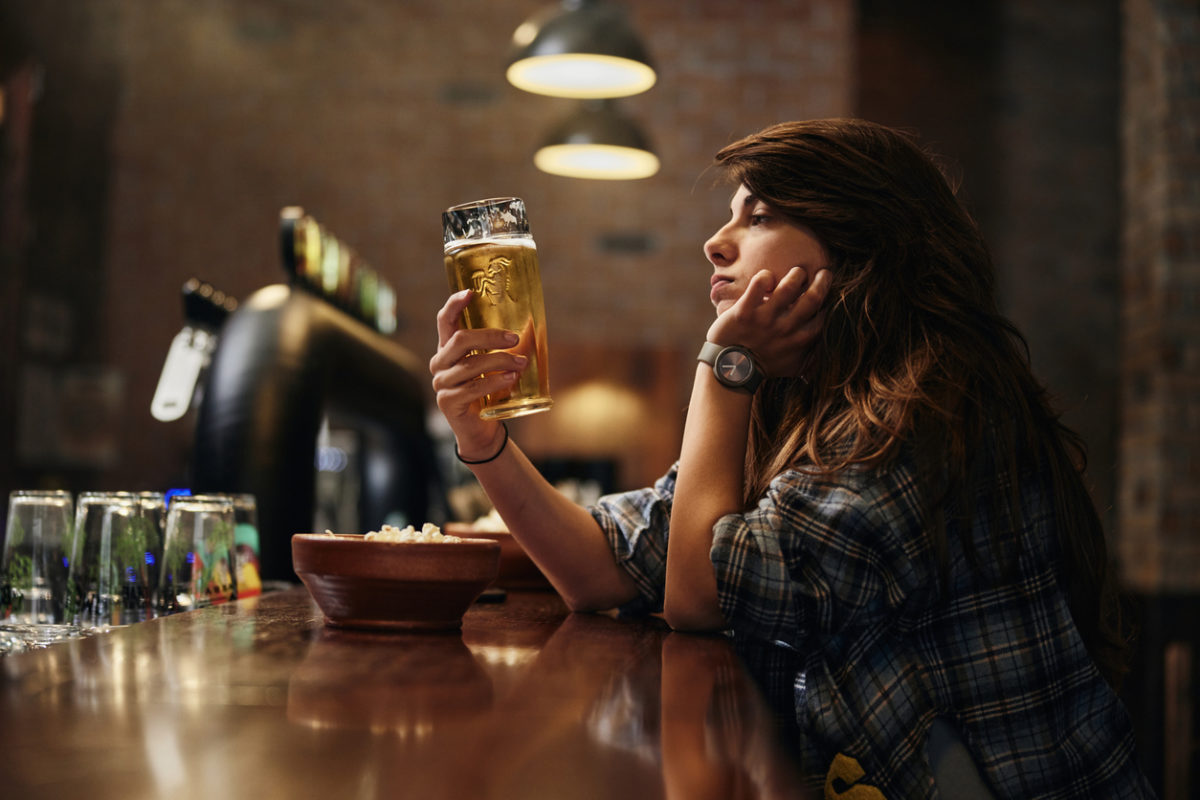 γυναίκα σε μπαρ πίνει αλκοόλ