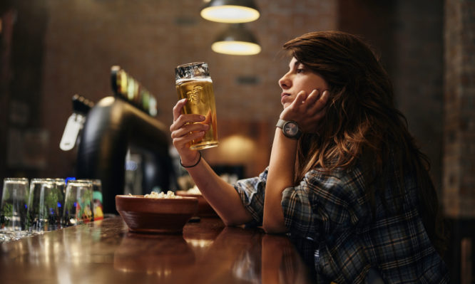 γυναίκα σε μπαρ πίνει αλκοόλ
